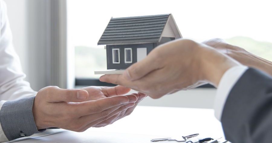 manos recibiendo la hipoteca de una vivienda y aceptando ciertas vinculaciones
