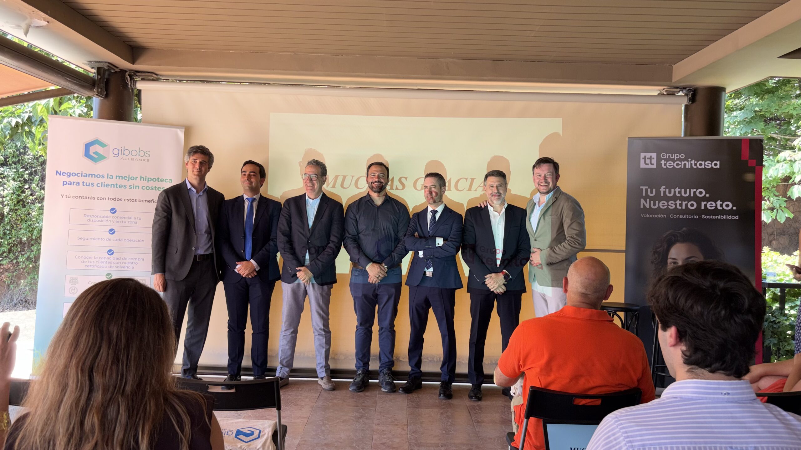 Trabajadores de gibobs allbanks posando ante una presentación.